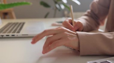 Anonim bir kadının stres dolu elinin yan görüntüsü işyerinde çalışırken masasını parmaklarıyla ritmik bir şekilde tıklatıyor görevlerini yerine getirirken baskı hissediyor..