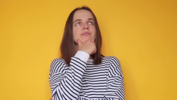 Thoughtful Woman Wearing Striped Casual Shirt Posing Isolated Yellow Background — Stock Video