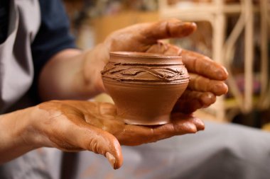 Sanat atölyesi. Islak kil. Geleneksel zanaat. Pervazları kapatıyorum. El yapımı kase. Yaratıcı usta. Potter 'ın elleri nazikçe ve kesinlikle çömlekçinin tekerleğindeki kil tencereyle şekillendi..