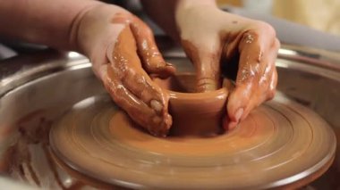 Yaratıcı seramik. Heykel çemberi. Çömlek ustası. Yetenekli bir zanaatkar. Şekillendirilmiş çömlek. Sanat seramikçisinin icatları. Usta çömlekçi atölyede çalışıyor. Ot ya da vazo yapıyor..