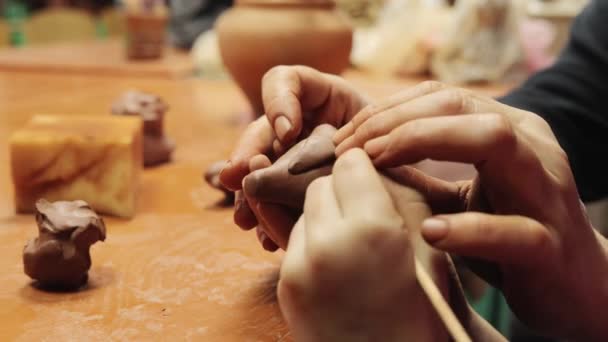 クリエイティブな陶芸工芸 陶芸ワークショップで働くマスターと認識できない子供が粘土図を作成し セラミックフォームを作成するスキルを開発 — ストック動画