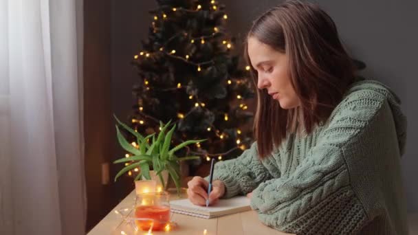 Jonge Bruinharige Vrouw Zit Aan Tafel Met Copybook Schrijven Verlanglijstje — Stockvideo