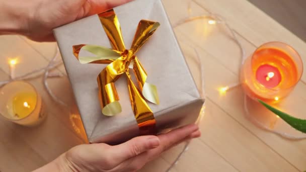 ホリデー クリスマス 冬の誕生日 家族のための贈り物を包む新年のための準備金の弓が付いている手の美しいギフト用の箱を握る認識できない女性 — ストック動画