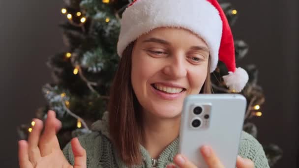 快乐的年轻貌美的女性在新年或圣诞期间 通过手机应用程序在社交网络上录制在线视频 向对方挥手致意 — 图库视频影像