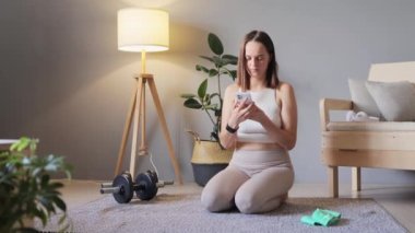 Spor salonunda sağlığım yerinde. Vücut bakımı için pilates. Esneklik için esneme hareketi. Sıska, sağlıklı genç bir kadın, zıt dizler ve eller kaldırıyor. Ev ödevi yaparken eşek tekmesi dengesi kuruyor..