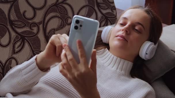 Calma Mujer Adulta Usando Teléfono Inteligente Móvil Auriculares Mientras Escucha — Vídeos de Stock