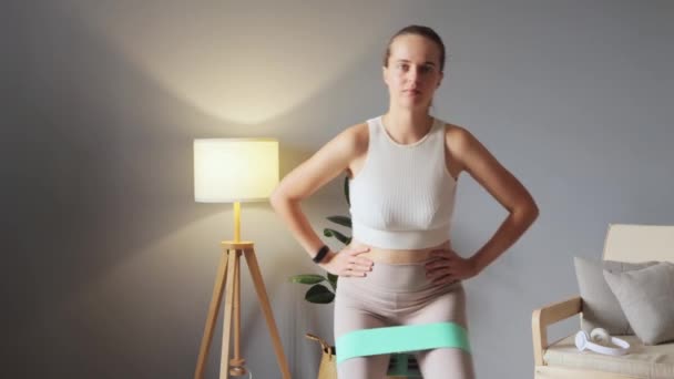 Biała Kobieta Beżowej Odzieży Sportowej Wykonująca Ćwiczenia Nóg Podłodze Paskiem — Wideo stockowe