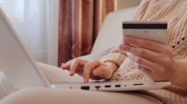 Bilinmeyen genç bir kadın, elinde dizüstü bilgisayarla dinleniyor ve internette geziniyor. İnternet üzerinden alışveriş yaparak veri girişi yapıyor..