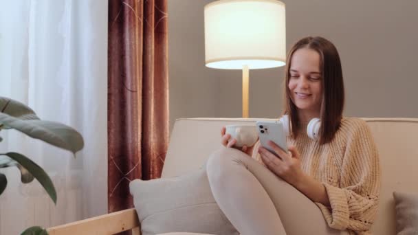Ung Kvinna Bär Casual Kläder Håller Handen Mobiltelefon Dricka Kaffe — Stockvideo