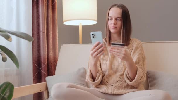 Kanepede Oturan Üzgün Kadın Internet Alıcısı Elinde Telefon Ile Kart — Stok video