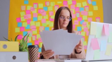 Sarı etiketli bilgisayar karşısında çalışan şok olmuş bir kadın raporunda bir sürü hata bulup işine konsantre olmaya çalışıyor..