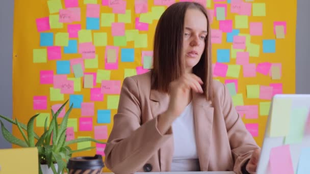 Vážná Koncentrovaná Žena Pracující Počítači Proti Žluté Zdi Barevnými Samolepkami — Stock video