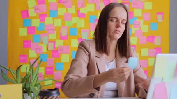 Nespokojeni Žena Pracující Notebooku Svém Pracovišti Pestrobarevnými Poznámkovými Kartami Psaní — Stock video
