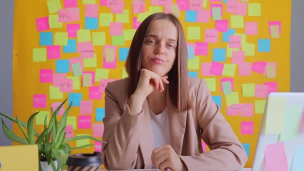 Mulher Incerta Trabalhando Computador Contra Parede Amarela Com Adesivos Coloridos — Vídeo de Stock