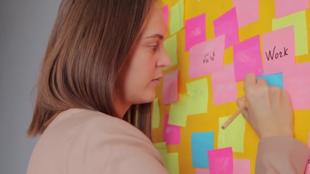 창조적인 사무실에서 계획을 끈끈한 노트에 심각한 집중된 다채로운 카드와 그녀의 — 비디오