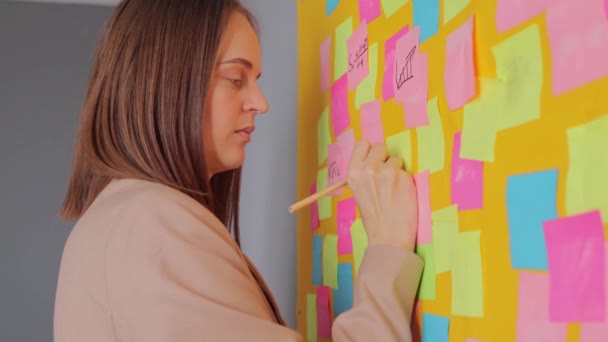 노트에 매력적인 여자는 사무실에서 계획을 베이지 프로젝트에 그녀의 생각을 — 비디오
