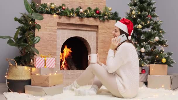 Mujer Alegre Sonriente Con Suéter Cálido Sombrero Santa Claus Sentado — Vídeo de stock