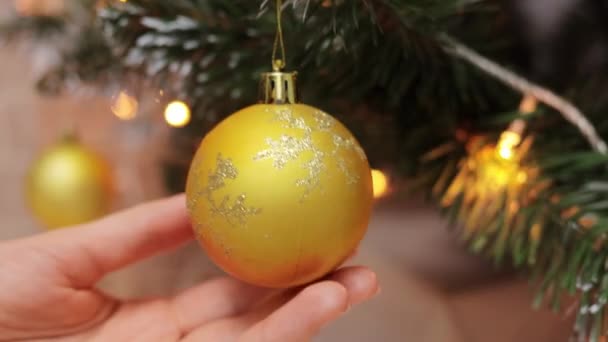 Weihnachtskugel Auf Dem Weihnachtsbaum Mit Verschwommenen Girlanden Lichter Auf Hintergrund — Stockvideo