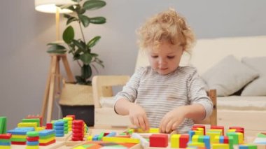 Eğitici oyuncaklar dersi. Montessori 'den esinlenilmiş tasnif. Çocukluk motor becerileri. Ufaklığın renkli oyunu. Anaokulu aktiviteleri. Küçük kız oyun odasında tahta şekilli bir oyuncakla oynuyor..