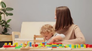 Aile oyun zamanı. Sosyal bağlar kuruyor. Kooperatif oyun aktiviteleri. Renkli gökkuşağı istifçisi. Organik duyusal oyun. Küçük kızıyla evde oynayan genç bir anne..