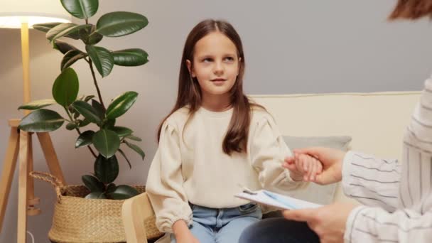 プロの心理学者と話す子供時代のトラウマを持っているブラウンハイレッド小さな少女は 小さな子供の問題を聞く手心理学者を保持するサポートを必要とします — ストック動画