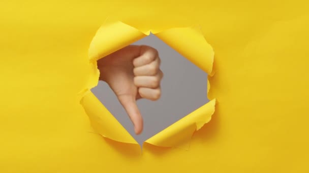 在黄色复制空间背景下突破纸孔撕破墙纸时 女性的手表现出不喜欢的手势 — 图库视频影像