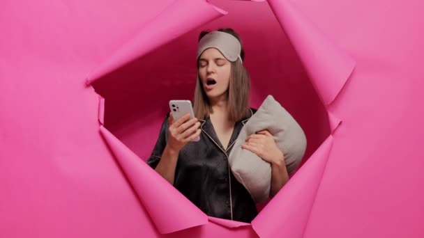 Сонна Жінка Сплячій Масці Піжамі Позує Паперовому Отворі Рожевої Стіни — стокове відео
