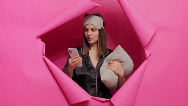Terkejut Ketakutan Wanita Mengenakan Topeng Tidur Dan Piyama Menggunakan Telepon — Stok Video