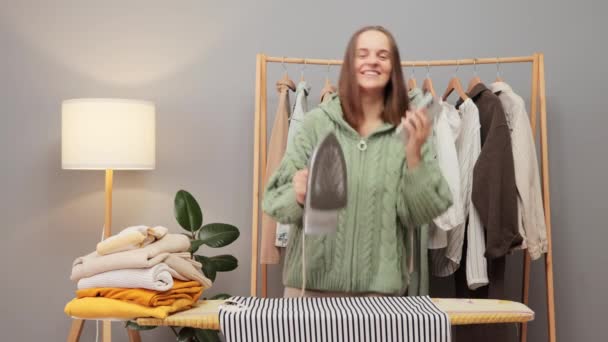 Χαρούμενη Ικανοποιημένη Καστανή Γυναίκα Που Φοράει Πλεκτό Πουκάμισο Σιδερώνει Ρούχα — Αρχείο Βίντεο