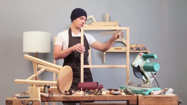 熟练的木匠精雕细琢地手工木制品 将原材料转化为实用的艺术品 年轻的木匠穿着围裙和帽子测量木制的空隙 — 图库视频影像