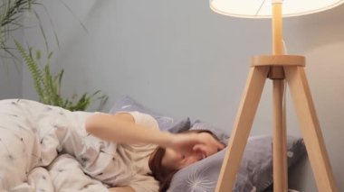 Genç, neşeli bir kadın uykuya dalıyor. Gece lambasını söndürüyor. Elektriği söndürüyor.