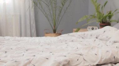 Yorgun bir kadın, tatmin olmuş yüzüyle yatağa düşüyor. Hafta sonu pijama giyiyor, yatak odasında dinleniyor. Gün boyu şekerleme yapıyor.