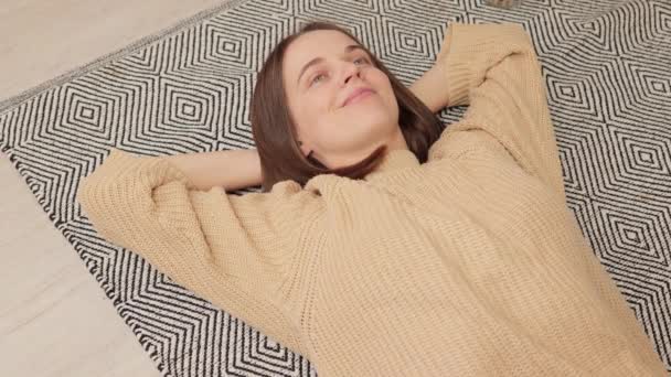 Χαρούμενη Χαρούμενη Γυναίκα Που Φοράει Πουλόβερ Ξαπλωμένη Στο Πάτωμα Απολαμβάνοντας — Αρχείο Βίντεο
