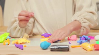 Heykel yapan çocuklar. Erken çocukluk yaratıcılığı. Anaokulu el işi zevki. Tanımlanamayan küçük kız renkli plastik parçalarla oynuyor.