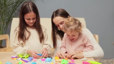 Çocuklar ve anneleri renkli kil oyuncaklar oynarken hafta sonunu evde birlikte geçiriyorlar. Çok renkli plastiklerle yaratıcı zamanların tadını çıkarıyorlar.