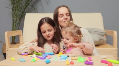Eğitici zanaat. Plastikli heykel. Sanat ve eğitim birleşimi. Evde yaratıcı bir oyun. Neşeli çocuklar anneleriyle birlikte çok renkli plastiklerle oynuyorlar.