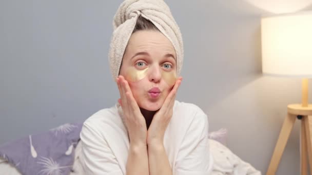 Funny Positive Woman Wrapped Towel Sitting Bedroom Eyes Patches Sending — Stock Video
