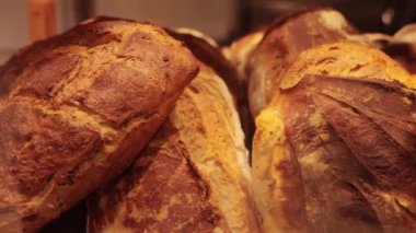 Organik ve lezzetli ekmek. Fırın ürünleri. Ekmek ürünlerinin üretimi ve satışı. Lezzetli doğal pastane ziyafeti. Fırının tezgahında bir somun taze ekmek..