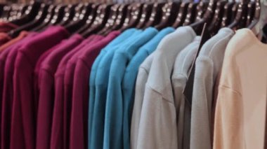 Moda mağazasındaki askıda süveterler. Klasik kadın kıyafetleri işte. Showroom 'da çok renkli kazaklar var. Balıkçı yaka yaka yaka yaka. Askılarda kalın elbiseler giyiyorlar.
