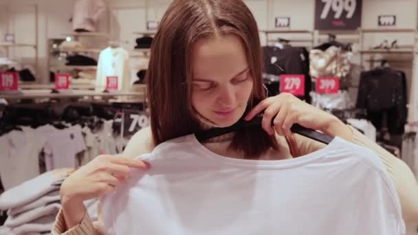 Brązowe Włosy Kaukaska Kobieta Wybierając Zniżki Shirt Ubrania Sklepie Centrum — Wideo stockowe