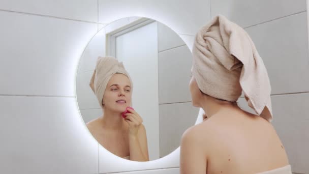 Hermosa Mujer Caucásica Envuelta Toalla Cabeza Mirando Espejo Reflejo Limpiando — Vídeo de stock