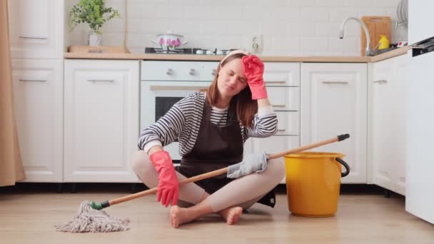 Smutna Nieszczęśliwa Młoda Kobieta Siedząca Obok Wiadra Rzeczami Sprzątania Kuchni — Wideo stockowe