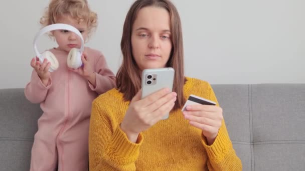 Konzentrierte Junge Frau Häuslicher Kleidung Sitzt Auf Dem Sofa Während — Stockvideo