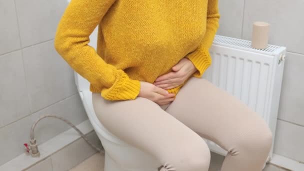 노란색 스웨터와 고통스러운 증상을 마사지 레깅스를 화장실에서 화장실 그릇에 Cystitis에서 — 비디오