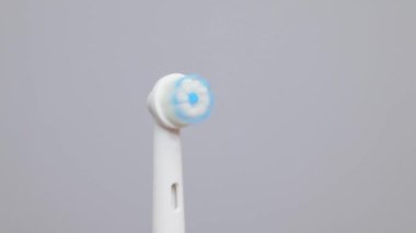 Modern elektrikli diş fırçası gri arka planda izole edilmiş. Günlük oral bakım için kontrollü araç.
