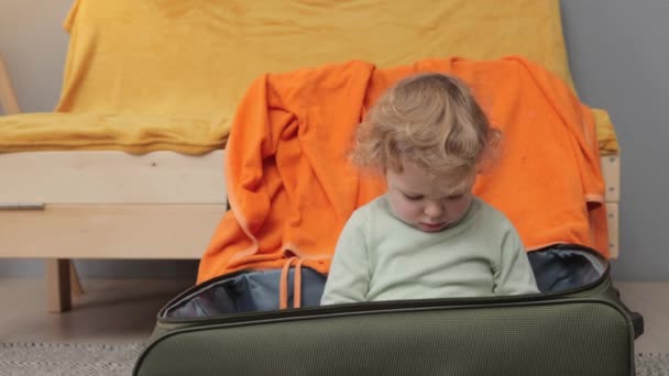Cute Little Child Blonde Wavy Haired Sitting Suitcase Clothes Playing — Stock Video