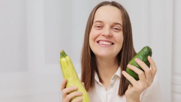 Felice Donna Caucasica Possesso Avocado Zucchine Mentre Piedi Sala Luce — Video Stock