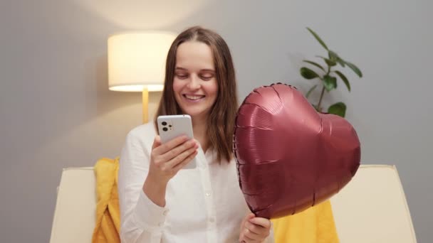 Wesoły Atrakcyjna Kobieta Czerwonym Kształcie Serca Balon Pomocą Smartfona Komunikacji — Wideo stockowe