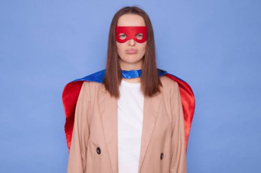 Üzücü üzgün kahverengi saçlı kadın süper kahraman kostümü giyiyor. Mavi arka planda soyutlanmış bir şekilde duruyor. Tatminsiz bir şekilde ifade etmek görevi başaramadı.