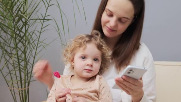 Kaukasische Braunhaarige Mutter Hält Smartphone Der Hand Und Zeigt Der — Stockvideo